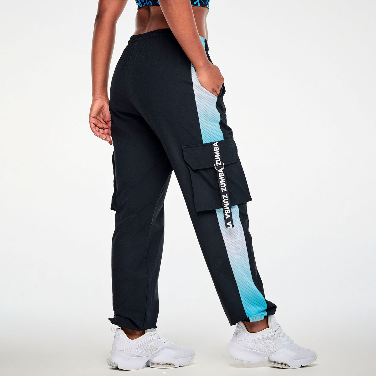 Czarne spodnie cargo unisex z siateczkowymi lampasami – widok z tyłu na modelce | Zumba Wear