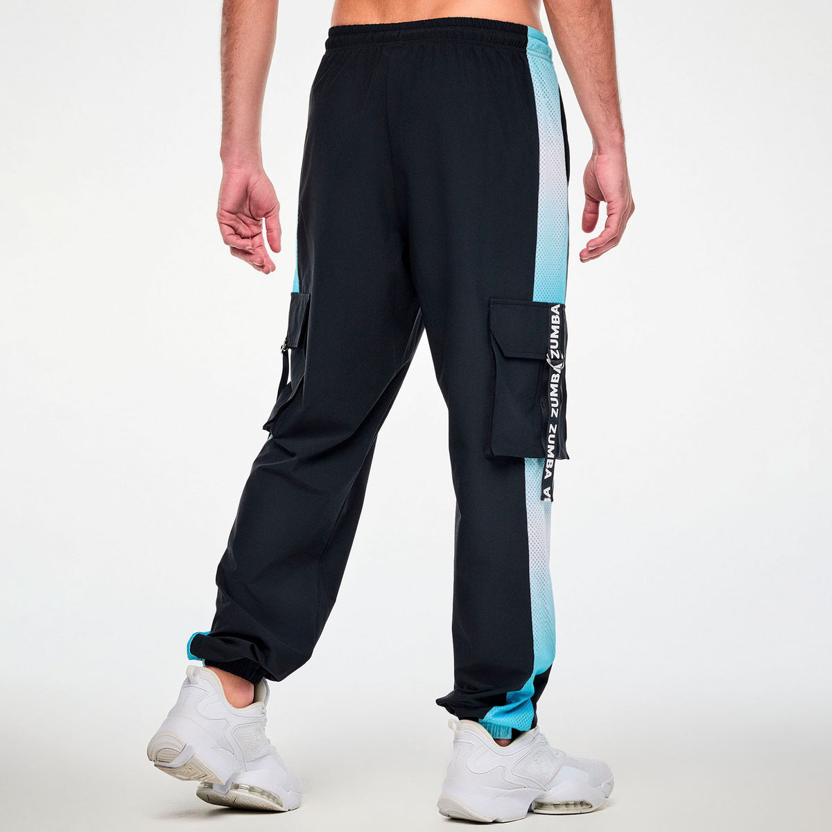 Czarne spodnie cargo unisex z siateczkowymi lampasami – widok z tyłu na modelu | Zumba Wear