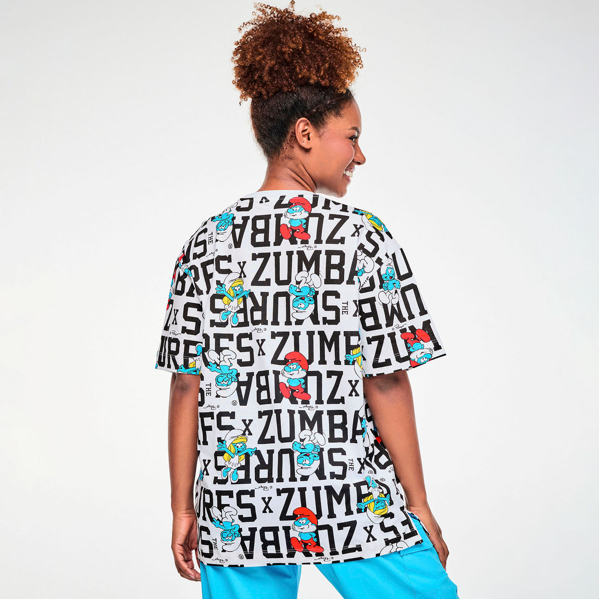 Biała koszulka oversize unisex w napisy i Smerfy – widok z tyłu na modelce | Zumba Wear