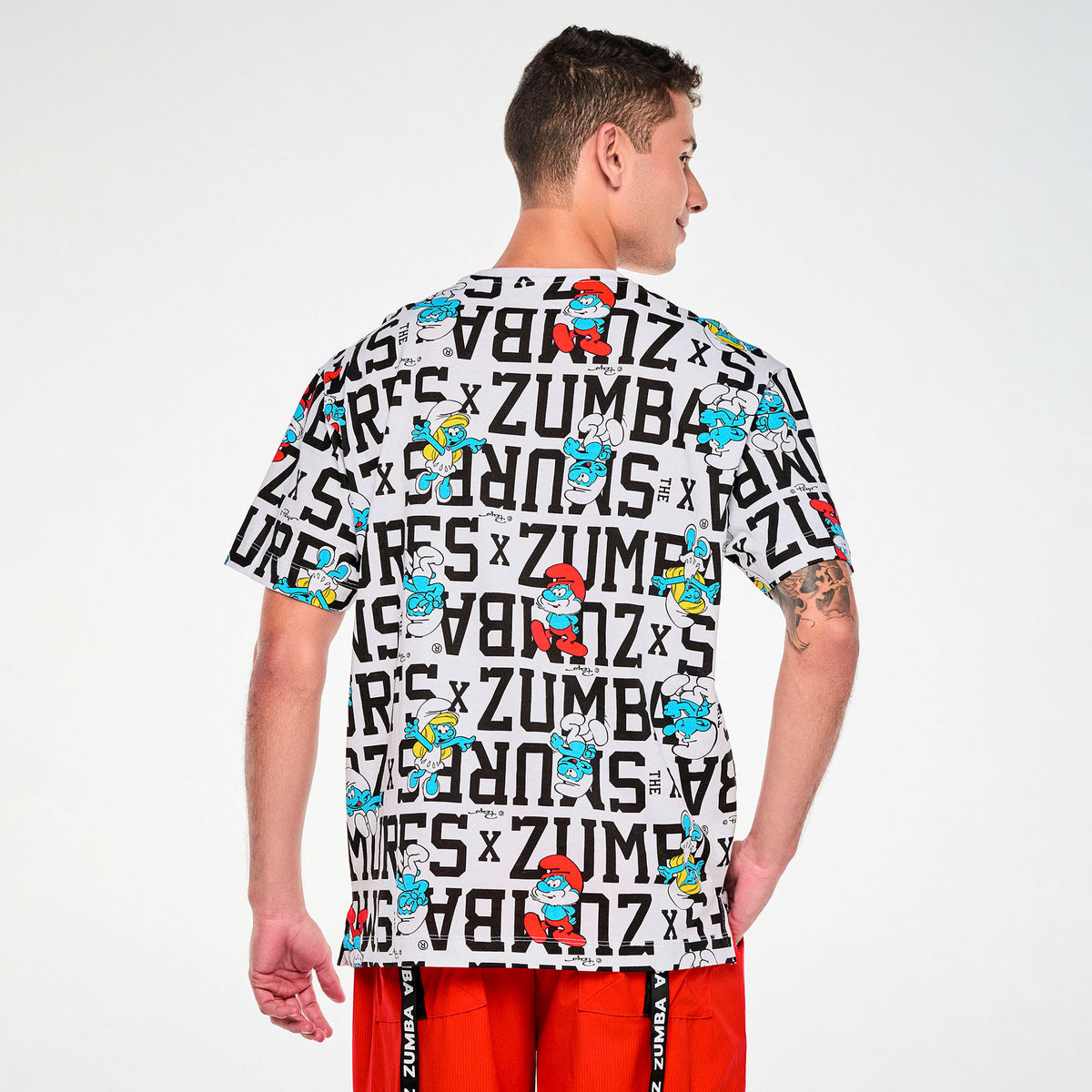 Biała koszulka oversize unisex w napisy i Smerfy – widok z tyłu na modelu | Zumba Wear