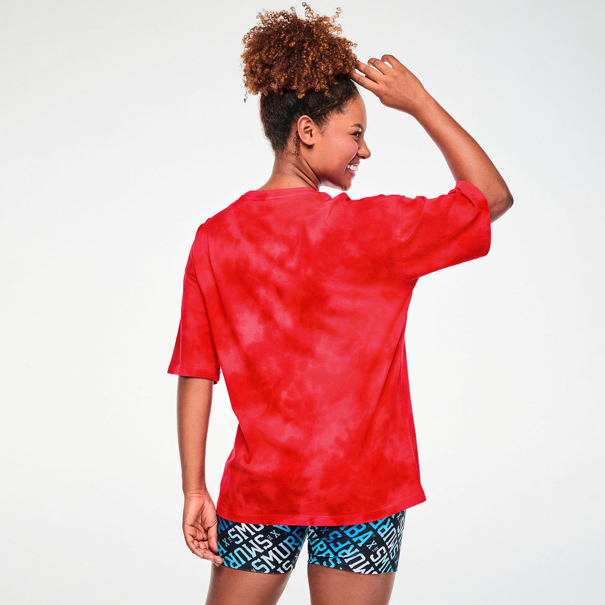 Czerwona koszulka oversize z Papą Smerfem – widok z tyłu na modelce | Zumba Wear