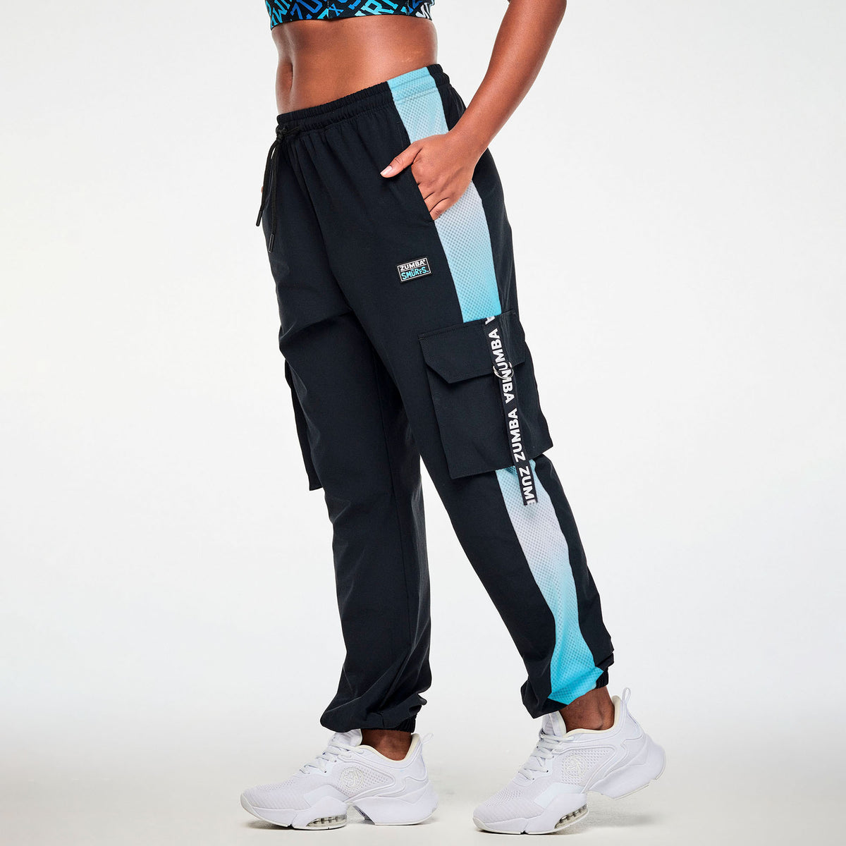 Czarne spodnie cargo unisex z siateczkowymi lampasami – widok z boku na modelce | Zumba Wear