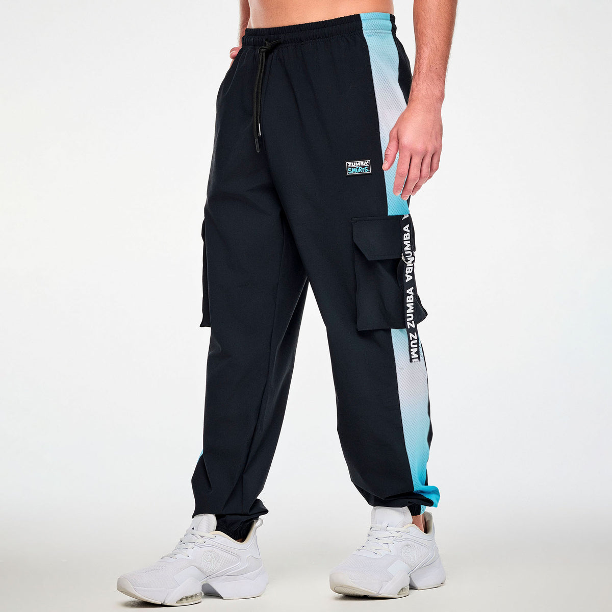 Czarne spodnie cargo unisex z siateczkowymi lampasami – widok z boku na modelu | Zumba Wear