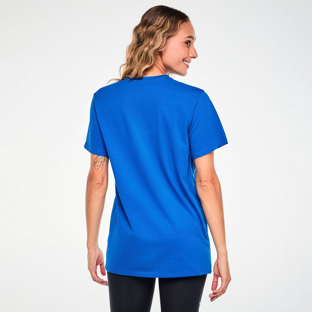Niebieska koszulka unisex ze Smerfami – widok z tyłu na modelce | Zumba Wear
